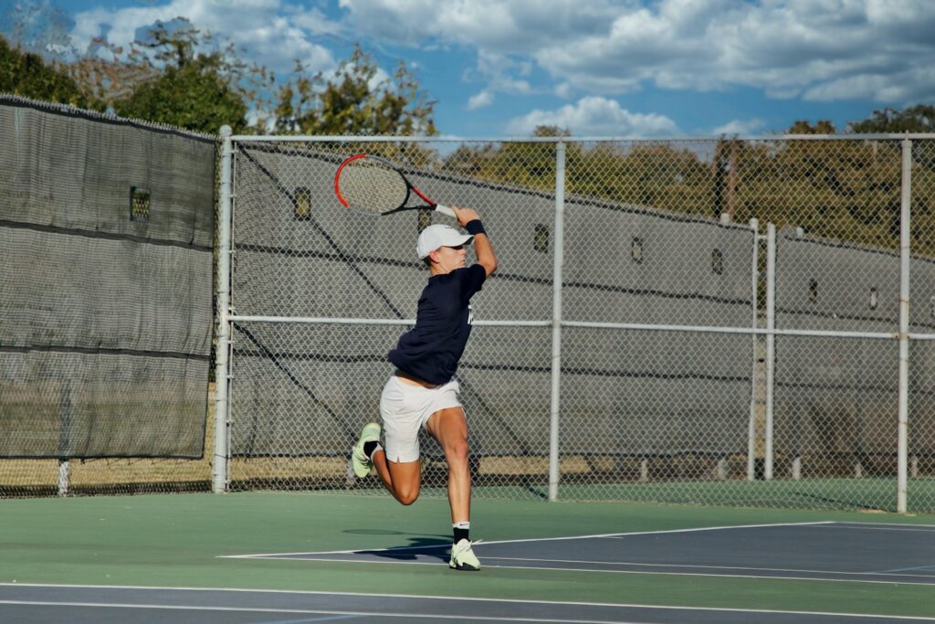 Tennis player in proper tennis attire on court